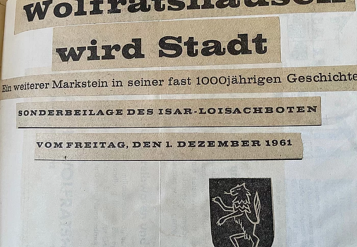 Historischer Zeitungsausschnitt mit der Überschrift "Wolfratshausen wird Stadt"